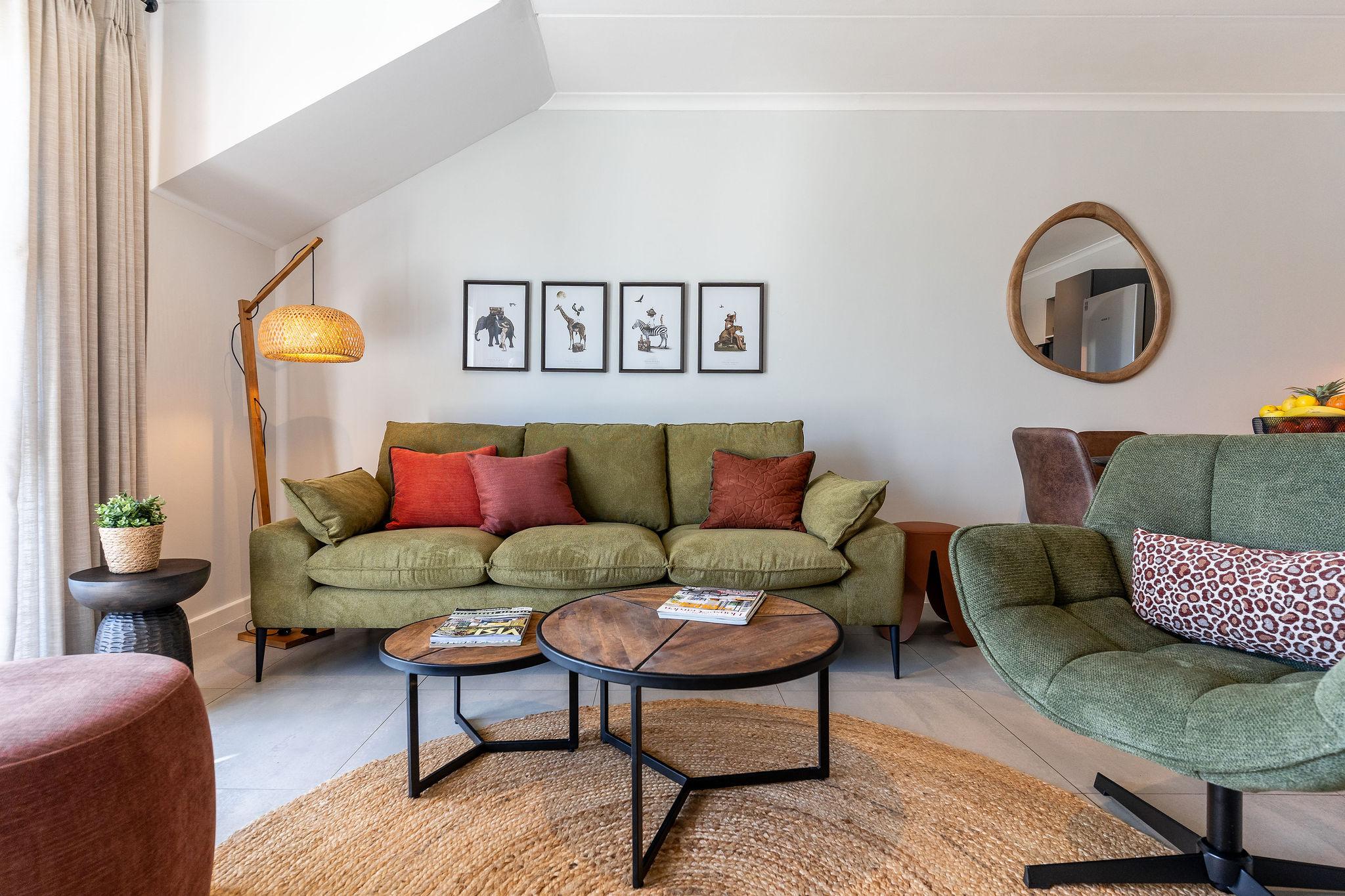 Cape Perlant lounge with a green sofa and framed wildlife prints