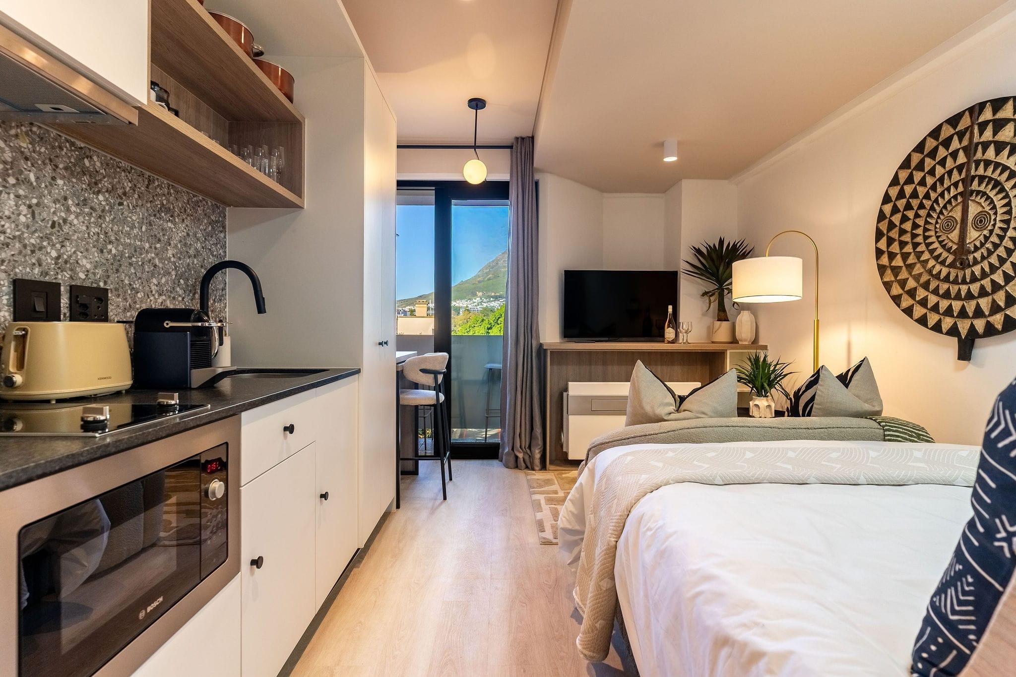 Mountainview studio with kitchenette, bed and a mountain view through the balcony door